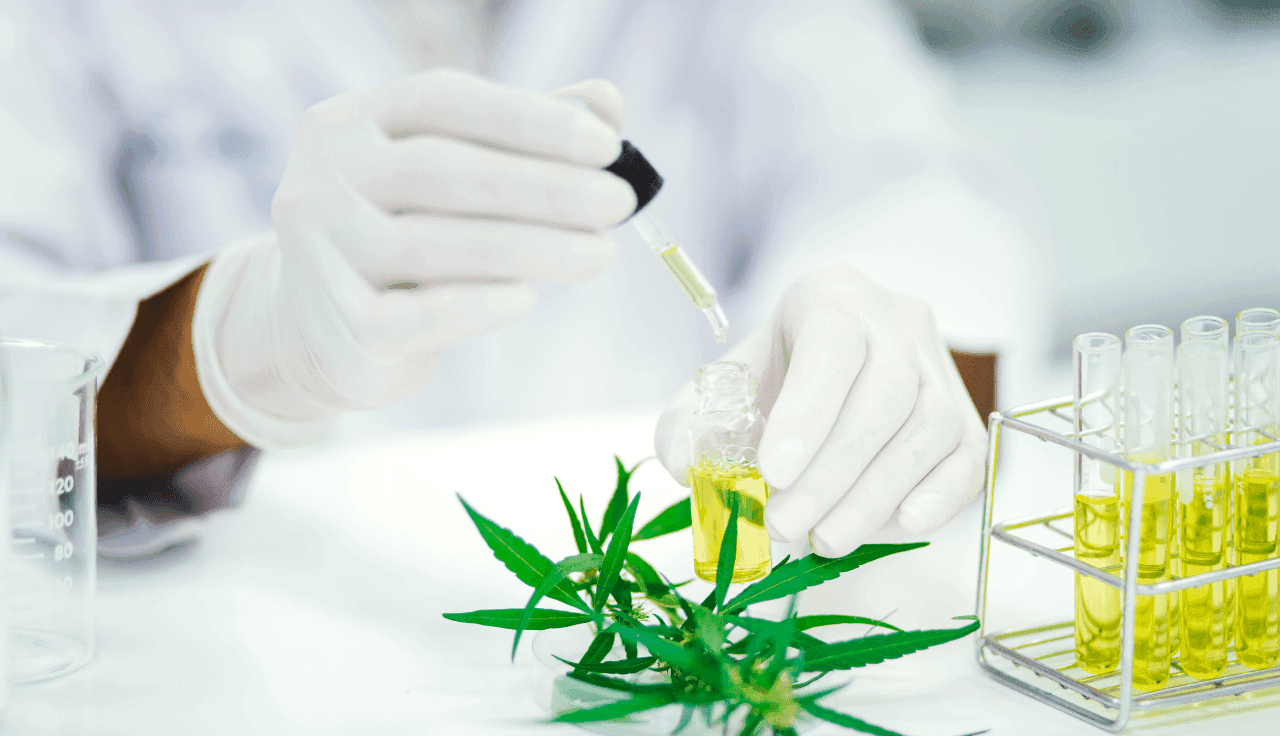 Eine Person füllt mit einer Pipette Öl in eine kleine Flasche